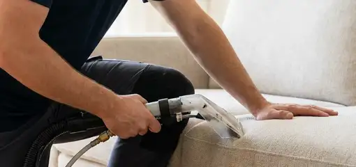Professional upholstery cleaner deep-cleaning a fabric sofa with a handheld extraction tool, Los Angeles, CA.
